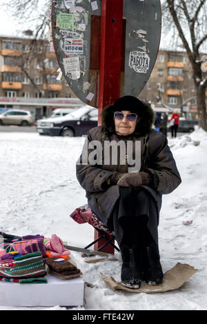 UFA - RUSSIE 1ER MARS 2016 - Une femme âgée est assise sur un strapontin avec un carton chauffe-pieds et vend donc en laine filée à la maison Banque D'Images