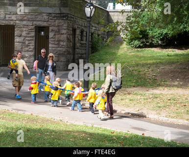 Groupe d'enfants d'école maternelle organiser et partager long ruban bleu en marchant dans Central Park à New York. Banque D'Images