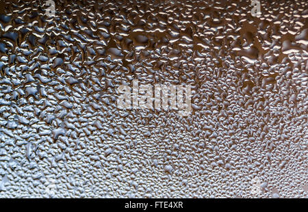 La Condensation forme des gouttelettes d'eau sur la surface d'une fenêtre en verre clair de l'intérieur de la chambre. Argent blanc et gris des t Banque D'Images