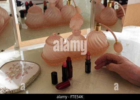 Flacons à parfum en verre rose sur une coiffeuse. Banque D'Images