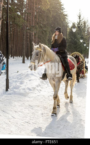 UFA - RUSSIE 22e Février 2016 - une jeune fille des manèges et exerce son cheval dans un parc public à Ufa en Russie au cours de l'hiver Banque D'Images