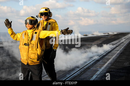 Maître de Manœuvre de l'aviation (manutention) 2e classe Christopher Turk, arrière, supervise l'Aviation maître de Manœuvre (manutention) Airman Jennifer Pereamarcial pendant les opérations de vol sur le pont du porte-avions USS Nimitz (CVN 68). Nimitz est déployé des opérations de sécurité maritime et les efforts de coopération en matière de sécurité dans le théâtre américain dans la 6ème zone d'opérations de la flotte. (U.S. Photo par marine Spécialiste de la communication de masse Matelot-Siobhana R. McEwen/ libéré) Banque D'Images