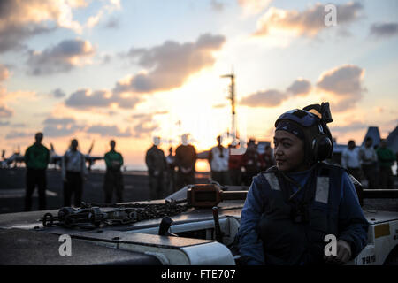Nicole Cruz, le compagnon de l'aviation Boatswain, supervise la descente du FOD (Foreign Object Damage) sur le pont d'envol de l'USS Nimitz (CVN 68), un porte-avions déployé en mer Méditerranée. Cette opération permet de s'assurer que le poste de pilotage est dégagé de tout débris qui pourrait endommager les aéronefs pendant les opérations. Banque D'Images