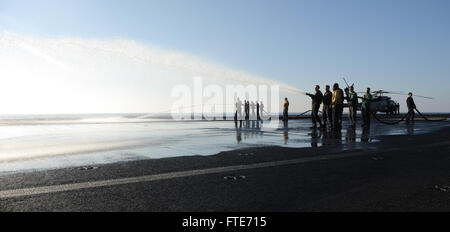 Mer Méditerranée (oct. 28, 2013) marins et Marines de l'homme un flexible pendant un vol Brosse lave-pont à bord du porte-avions USS Nimitz (CVN 68). Nimitz est déployé des opérations de sécurité maritime et les efforts de coopération en matière de sécurité dans le théâtre américain dans la 6ème zone d'opérations de la flotte. (U.S. Photo par marine Spécialiste de la communication de masse Seaman Apprentice Kelly M. Agee/ libéré) Banque D'Images