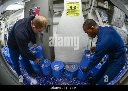 Le 28 octobre 2013, à bord de l'USS Monterey (CG 61) en Méditerranée, des marins ont transféré des bouteilles de mousse formant film aqueux (AFFF) lors d'opérations de contrôle des dégâts. Cette action courante faisait partie des opérations de sûreté maritime du navire dans la zone d'opérations de la 6e flotte américaine. Banque D'Images