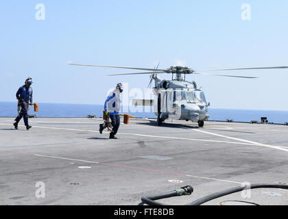 140812-N-VY489-105 MER MÉDITERRANÉE (Août 12, 2014) les marins de la fonction publique dépose des cales et des chaînes d'un MH-60S Sea Hawk est attribuée à ce "Ghostriders, hélicoptère de combat" de la mer de l'Escadron (HSC) 28 avant son décollage de la sixième flotte américaine navire de commandement et de contrôle USS Mount Whitney (LCC 20). Le Mont Whitney, homeported à Gaeta, Italie, fonctionne avec un équipage de marins et de la commande de transport maritime militaire civil service aux marins. (U.S. Photo par marine Spécialiste de la communication de masse 2e classe Mike Wright/libérés) Banque D'Images