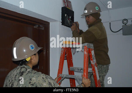 140207-N-ZZ999-003 ROTA, ESPAGNE (fév. 7, 2014) - électricien de construction 3e classe Romnick tests Gerona le courant sur une enseigne de sortie comme apprenti électricien en construction Constructionman Ashley Garcia les plans tremblotants l'échelle, dans le cadre de la maintenance à bord Camp Mitchell, Rota, Espagne. Avant d'exploitation, NMCB 74 s'efforce de tirer parti des occasions d'engagement et de construire des relations durables, en fin d'ouvrir la voie à de futurs partenariats. (U.S. Photo par Marine Builder Constructionman Mallory Getty/libérés) Inscrivez-vous à la conversation sur Twitter ( https://twitter.com/naveur navaf ) Suivez-nous Banque D'Images