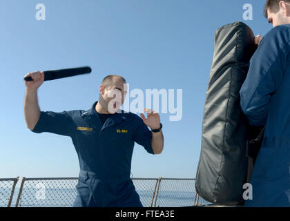 Lieutenant Junior Grade Andy A. Muscarello, officier de l'U.S. Navy, pratiquant des tactiques d'armes non létales à bord de l'USS Ramage, un navire impliqué dans une opération navale axée sur la sécurité maritime et la coopération en matière de sécurité théâtrale en Méditerranée. Banque D'Images