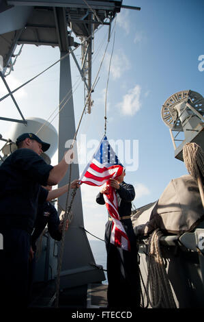 Cette photo capture le matelot de quartier-maître Kevin Hopkins et le spécialiste en chef de la logistique Calvin Hou à bord de l'USS Arleigh Burke, qui se préparent à hisser l'enseigne nationale en l'honneur d'un petit officier en chef à la retraite lors d'un déploiement en mer Méditerranée. Banque D'Images