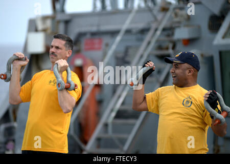 Une photographie capturant le chef-maître du commandement Joseph O'Brien et le chef principal Raymond James participant à un événement d'entraînement physique sur l'USS Ramage (DDG 61). Cet événement honore le 121e anniversaire du grade de premier maître et reflète l'engagement de la Marine envers les opérations de sécurité maritime et la coopération en matière de sécurité sur le théâtre. Banque D'Images