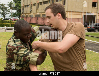 140414-N-NQ697-058 Douala, Cameroun (14 avril 2014) - Maître de 2e classe Jordanie Carter démontre une technique de retrait à seaman recruter Mombo Mapola Gabon, marine, au cours d'une perquisition et saisie la familiarisation à Douala au Cameroun dans le cadre de l'exercice Obangame Express 2014. Obangame Express est un golfe de Guinée maritime multinationale à base d'exercice visant à améliorer la coopération, l'interdiction de l'expertise et l'échange d'information entre les pays d'Afrique occidentale et centrale des Forces maritimes afin d'accroître la sécurité maritime et la sécurité dans la région. (U.S. Photo par marine Spécialiste de la communication de masse 3e Banque D'Images