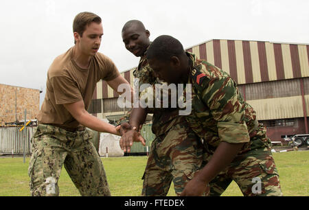 140414-N-NQ697-063 Douala, Cameroun (14 avril 2014) - Maître de 2e classe Jordanie Carter fait preuve d'une manœuvre de retrait marins Gabon Mibissa falaise, centre, et Kassouaoui Labibi, droite, lors d'une perquisition et saisie la familiarisation à Douala au Cameroun dans le cadre de l'exercice 2014 Obangame Express (OE-14). OE-14 est un golfe de Guinée maritime multinationale à base d'exercice visant à améliorer la coopération, l'interdiction de l'expertise et l'échange d'information entre les pays d'Afrique occidentale et centrale des Forces maritimes afin d'accroître la sécurité maritime et la sécurité dans la région. (U.S. Photo par Marine Co Masse Banque D'Images