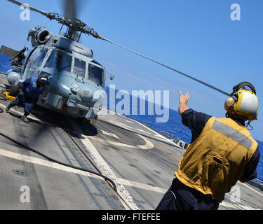 Mer Méditerranée (18 juillet 2014) Maître de Manœuvre 2e classe Adam Wendt des signaux à un SH-60B Seahawk pendant les opérations de vol comme maître de Manœuvre Seaman Sierra Alexander retourne à son poste à bord de la classe Ticonderoga croiseur lance-missiles USS Vella Gulf (CG 72). Vella Gulf, homeported à Norfolk, Va., mène des opérations navales des Alliés dans la sixième flotte américaine zone d'opération, afin de faire avancer la sécurité et la stabilité en Europe. Banque D'Images