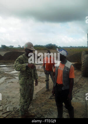 MONROVIA, Libéria (3 octobre 2014) Hospital Corpsman 2e classe Timothy Dandridge, affectés à la construction navale Bataillon mobile(NMCB) 133, va au-dessus des plans avec un opérateur local à une unité médicale de Monrovia site à Monrovia, au Libéria, à l'appui de l'opération United de l'aide. 133 NMCB fournira l'ingénierie initiale les évaluations de sites dans les domaines du Libéria où les unités de traitement de l'Ebola sera construit. Banque D'Images