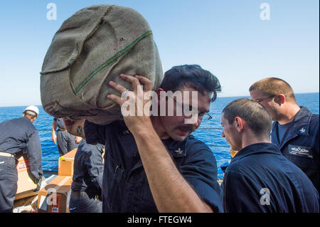 Une photographie prise le 7 octobre 2014, montrant Fire Controlman 2nd Class Robert Briscoe en train de transporter des fournitures lors d'un ravitaillement en mer à bord de l'USS Cole (DDG 67), un destroyer à missiles guidés de l'US Navy. Banque D'Images