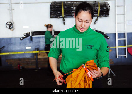 Mer Méditerranée (oct. 28, 2014) Technicien en électronique d'aviation 3ème classe Raven Volk, de Homer, Alaska, les coupures des liens zip sur sacs de courrier à bord du porte-avions USS George H. W. Bush (CVN 77). George H. W. Bush, homeported à Norfolk, Va., mène des opérations navales dans la sixième flotte américaine zone d'opérations à l'appui de la sécurité nationale américaine en Europe Banque D'Images