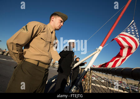 VALENCIA, Espagne (31 déc. 29, 2014) Un milieu marin avec la 24e Marine Expeditionary Unit, "le mans" alors que les rails avec les marins Iwo Jima groupe amphibie, hisser le drapeau du pays à bord du USS Fort McHenry (LSD 43) Le 29 décembre 2014. La 24e MEU et Iwo Jima ARG mènent des opérations navales dans la sixième flotte américaine zone d'opérations à l'appui de la sécurité nationale des États-Unis en Europe. Banque D'Images