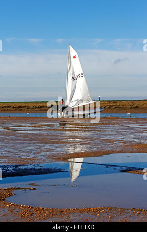 Un canot à voile avec équipage unique dans l'échouage à Burnham Overy Staithe, Norfolk, Angleterre, Royaume-Uni. Banque D'Images