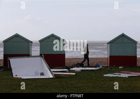 Brighton, UK. Mar 28, 2016. Un passant regarde endommagé des cabines de plage à Hove après les vents et l'eau apportée par la tempête de la côte battue Katie à Brighton, East Sussex, UK Lundi 28 mars, 2016. BBC sont des 'Storm Katie a vu des rafales jusqu'à 105mph battues Angleterre et Pays de Galles, avec plusieurs vols détournés des aéroports et grands ponts fermer'. Credit : Luke MacGregor/Alamy Live News Banque D'Images