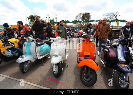 Southend on Sea, Royaume-Uni. 28 mars 2016. Un rassemblement animé de passionnés de scooters et de motos dans un cadre festif en plein air. Différents modèles et couleurs de scooters, dont turquoise, blanc, orange et noir, sont stationnés à côté des motos. Les participants en équipement d'équitation s'engagent dans la conversation, avec des lumières décoratives et des structures de foire en arrière-plan. Rallye annuel de motos Southend Shakedown sur le front de mer de Southend. Les motocyclistes vont de l'Ace Cafe, North Circular Road, Londres à Southend. Penelope Barritt/Alamy Live News Banque D'Images