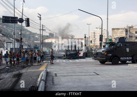 Rio de Janeiro, Brésil. 28 mars, 2016. Un groupe de personnes détenues Madureira rues du quartier pour protester contre la mort d'un garçon de 4 ans qui était un résident de la région. L'enfant a été touché par une balle perdue au cours d'un affrontement entre les trafiquants qui dominent les bidonvilles de Cajueiro et Serrinha. Pendant la manifestation, des vandales ont mis le feu à un autobus articulé le BRT (qui sera utilisé pendant les Jeux Olympiques de 2016, il relie l'aéroport international au Parc olympique) et également mis le feu à un autre bus standard. Deux stations de BRT furent vandalisés. Credit : Luiz Souza/Alamy Live News Banque D'Images