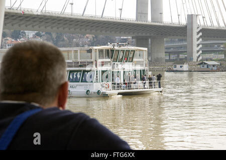 La rivière Sava, Belgrade, Serbie - Senior sailor regarde le bateau de tourisme en passant par d'une péniche ancrée Banque D'Images