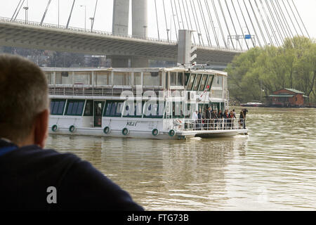 La rivière Sava, Belgrade, Serbie - Senior sailor regarde le bateau de tourisme en passant par d'une péniche ancrée Banque D'Images