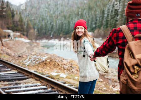 Happy young couple holding hands with Backpacks et marcher le long de chemins de montagne Banque D'Images