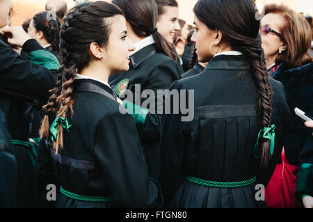 Deux filles parler entouré par des gens avant la procession. Semana Santa, Espagne Banque D'Images