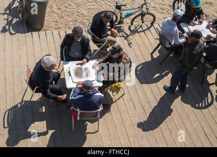 De vieux hommes jouant aux dominos à la plage de Barceloneta à Barcelone Banque D'Images