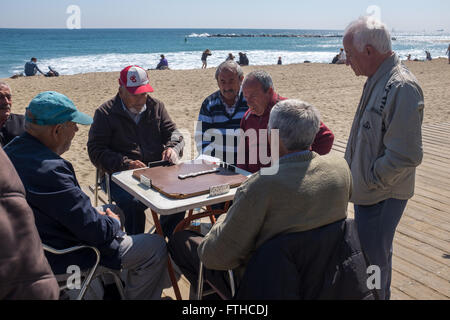 De vieux hommes jouant aux dominos à la plage de Barceloneta à Barcelone Banque D'Images