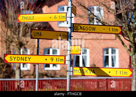 L'ahus, Suède - 20 mars 2016 : Street sign avec différents réglages de temps par rapport à la Suède. La construction en arrière-plan. Banque D'Images