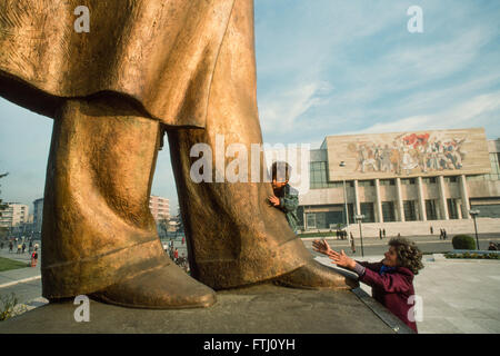 Jeune garçon, encouragé par sa mère, embrassant les pieds de la statue d'Enver Hoxha, le fondateur de l'état communiste, Tirana, 1990 Banque D'Images