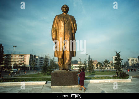 Jeune garçon, encouragé par sa mère, embrassant les pieds de la statue d'Enver Hoxha, le fondateur de l'état communiste, Tirana, 1990 Banque D'Images