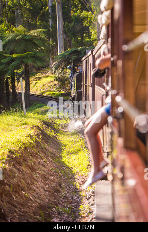 Jeune fille assise sur le bord du train Banque D'Images