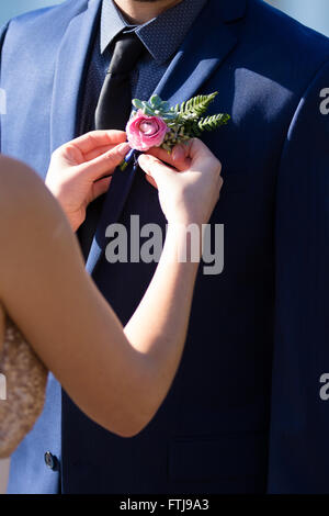 L'épinglage mariée une boutineer sur son fiancé le jour de leur mariage dans l'Oregon. Banque D'Images