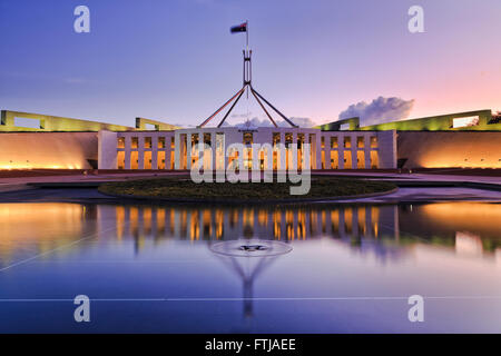 Reflet de couleur Canberra dans le nouveau bâtiment du parlement dans un étang fontaine au coucher du soleil. Banque D'Images