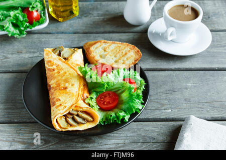 Omelette aux champignons sur une assiette avec salade et tomate Banque D'Images