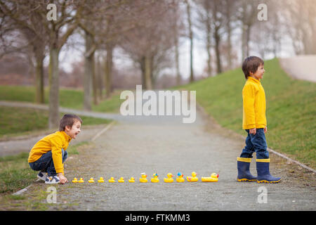 Deux adorables enfants, frères, Garçon jouant dans parc avec des canards en caoutchouc, plaisir. Le bonheur de la petite enfance concept Banque D'Images