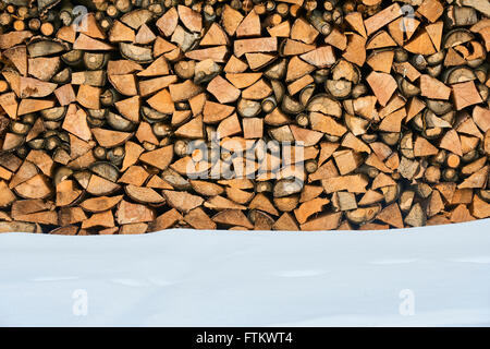 Bois de chauffage empilé en hiver. Pile de bois avec la neige empilés pour bois de chauffage Banque D'Images