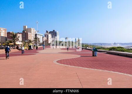 Inconnus à pied et du vélo le long promenade pavée contre city skyline à Durban, Afrique du Sud Banque D'Images