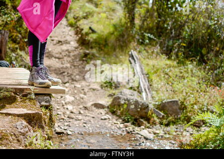 Mountaineer fille debout sur le bord d'un petit pont de bois Banque D'Images