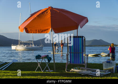 Parasol et chaises de plage sur la pelouse au bord de la Lagoa da Conceicao Banque D'Images