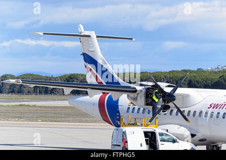 Mécanicien est de procéder à l'entretien d'avion de ligne de service -ATR 42-, -d-, compagnie aérienne Swiftair décollent dans l'aéroport de Madrid (Espagne) Banque D'Images