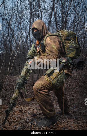 Camouflage Sniper portant fusil avec promenade dans les bois Banque D'Images