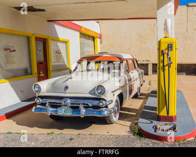 Classic 1950 Station Shell peint en jaune et rouge en couleurs et de Shell avec un 1952 Ford station wagon garé en face. Banque D'Images