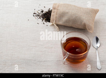 Le thé noir dans un verre tasse et théière en verre fraîchement préparée sur une serviette d'un saccage Banque D'Images