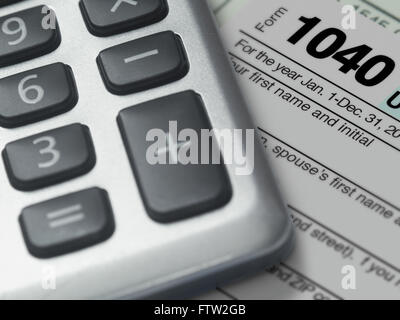 Photographie d'une calculatrice et un formulaire IRS 1040 in close up, illustrant le dépôt l'impôt sur le revenu fédéral américain. Banque D'Images