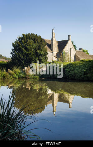 Les réflexions dans le Wiltshire village étang dans Biddestone près de Chippenham Banque D'Images