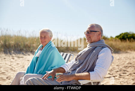 Happy senior couple dans des chaises sur la plage d'été Banque D'Images